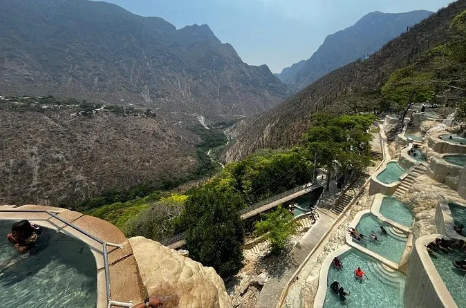 Pozas termales en la ladera con el cañón al fondo