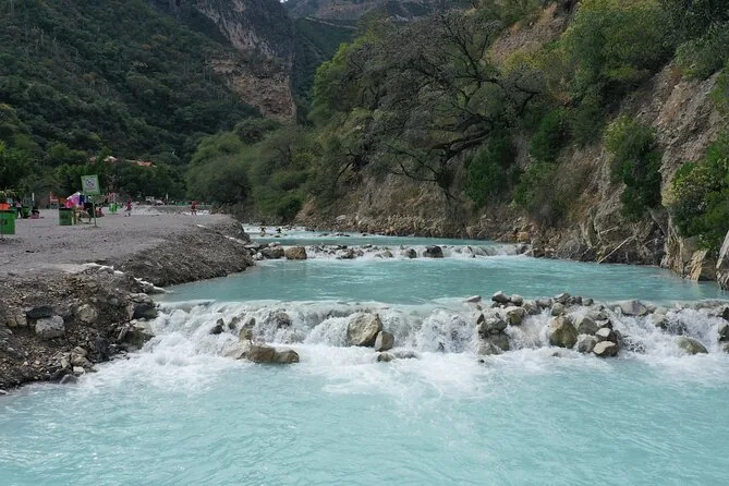 Shallow turquoise water flowing over pale rocks